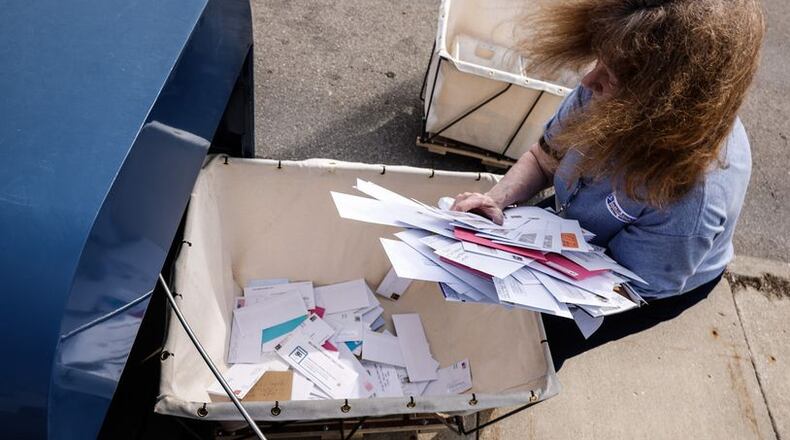 A postal worker removes mail from an outdoor Kettering post office. Police this past weekend in Kettering arrested three people in connection with a suspected theft of mail at the United States Post Office at 1490 Forrer Boulevard. JIM NOELKER/STAFF