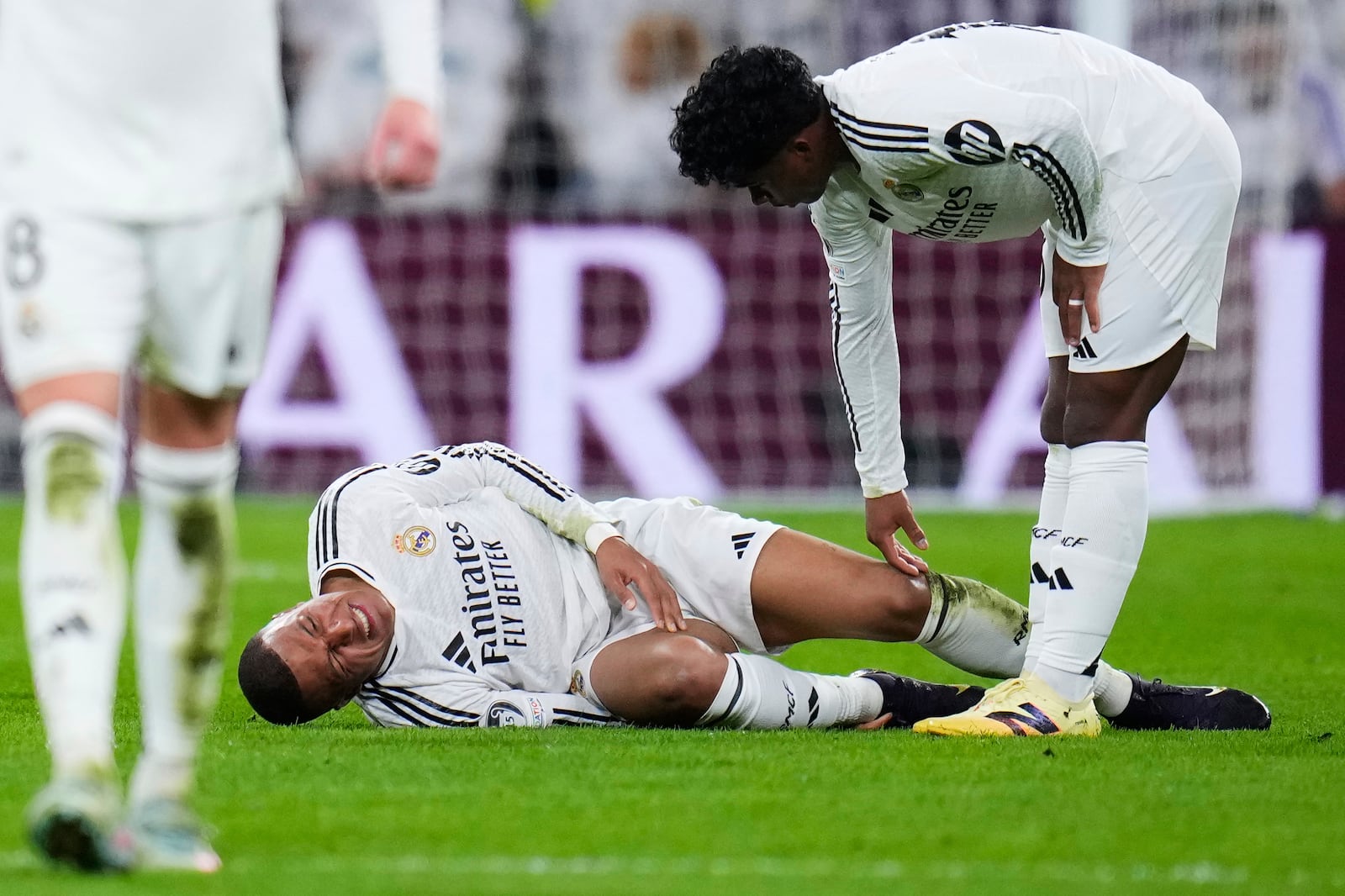 Real Madrid's Kylian Mbappe grimaces on the ground after getting injured during the Champions League quarterfinals second leg soccer match between Real Madrid and Arsenal at the Santiago Bernabeu stadium in Madrid, Wednesday, April 16, 2025. (AP Photo/Manu Fernandez)