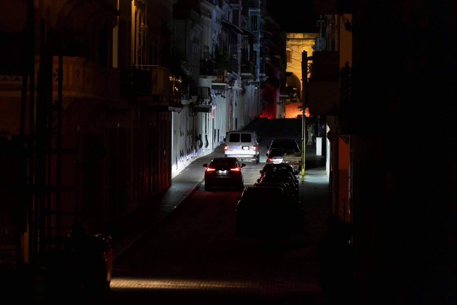Vehicles navigate a dark street in Old San Juan, Puerto Rico, during an island-wide blackout, Wednesday, April 16, 2025. (AP Photo/Alejandro Granadillo)