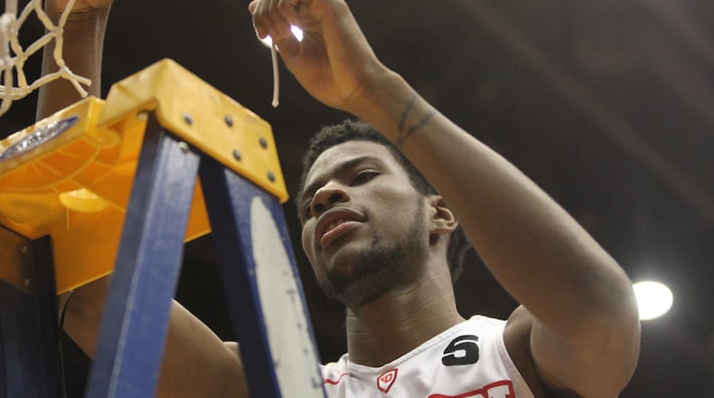 Dayton's Xeyrius Williams cuts down the net after a victory against Virginia Commonwealth on March 1, 2017, at UD Arena.