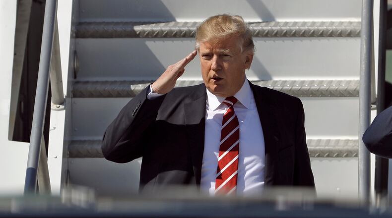 FILE - In this Monday, Feb. 6, 2017, file photo, U.S. President Donald Trump salutes as he arrives on Air Force One at MacDill Air Force Base, in Tampa, Fla. New Zealand's Prime Minister Bill English said Tuesday he told Trump during a phone call that he disagreed with his travel and refugee ban but that the conversation remained amicable. (AP Photo/Chris O'Meara/File)