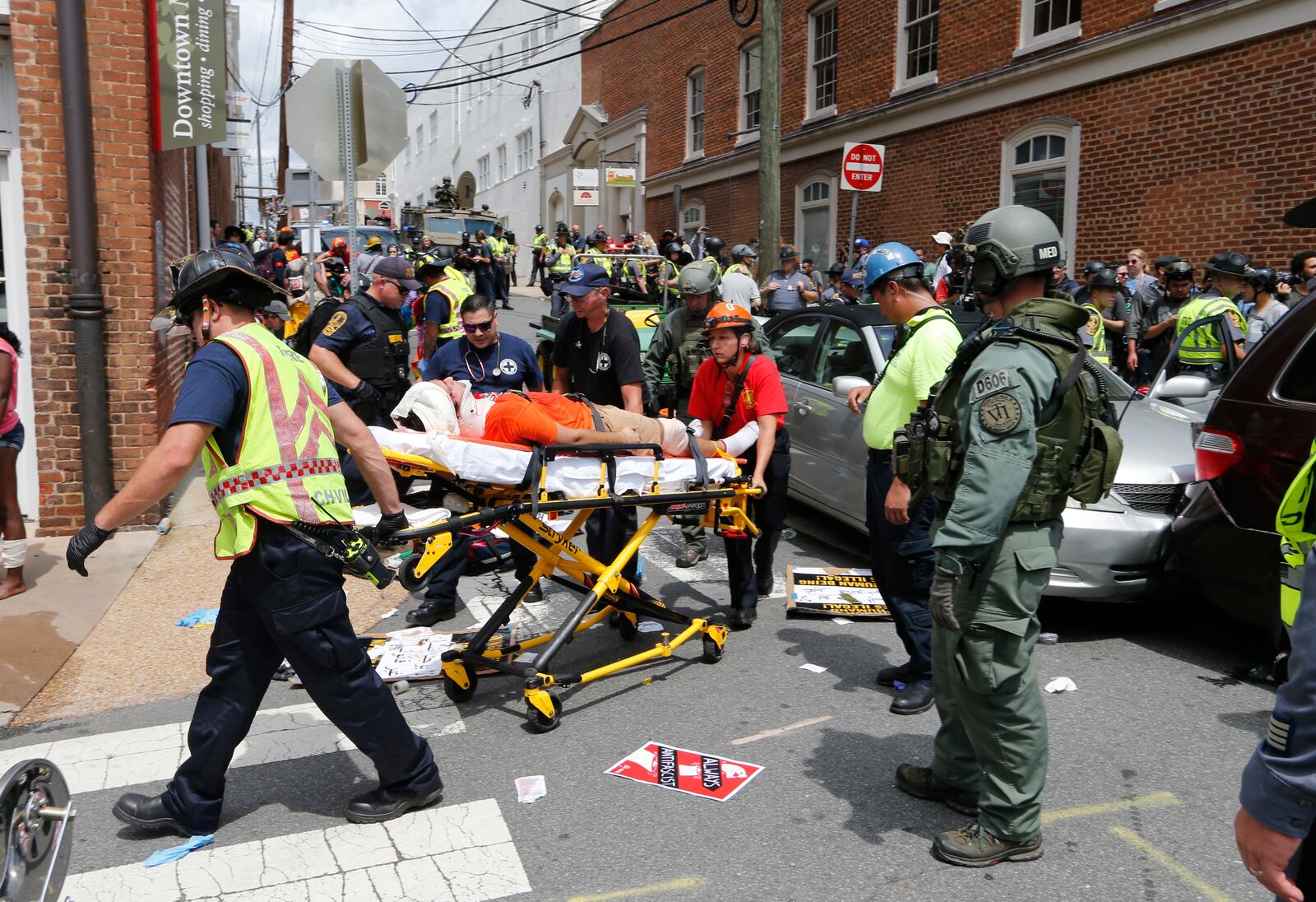 Rescue personnel help injured people after a car ran into a large group of protesters after a white nationalist rally in Charlottesville, Va., Saturday, Aug. 12, 2017.  The rally was to protest plans by the city of Charlottesville to remove a statue of Confederate Gen. Robert E. Lee. There were several hundred protesters marching in a long line when the car drove into a group of them. (AP Photo/Steve Helber)