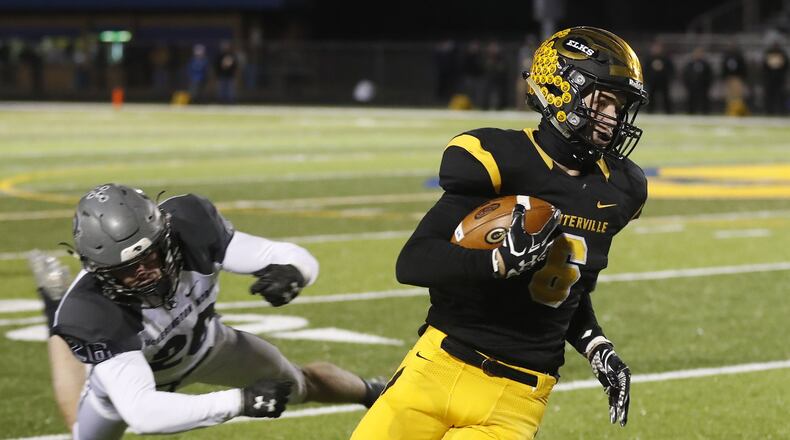 Centerville’s Riley Poulton avoids a tackle by Pickerington North’s Ben Johnson during their playoff game in Springfield. Bill Lackey/Staff