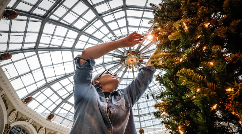 Friends of the Dayton Arcade volunteer Anna Hunsberger arranges Christmas tree branches at the Dayton Arcade Monday December 9, 2024. Hunsberger and other volunteers put together dozens of trees in the rotunda for Holly Days 2024. JIM NOELKER/STAFF