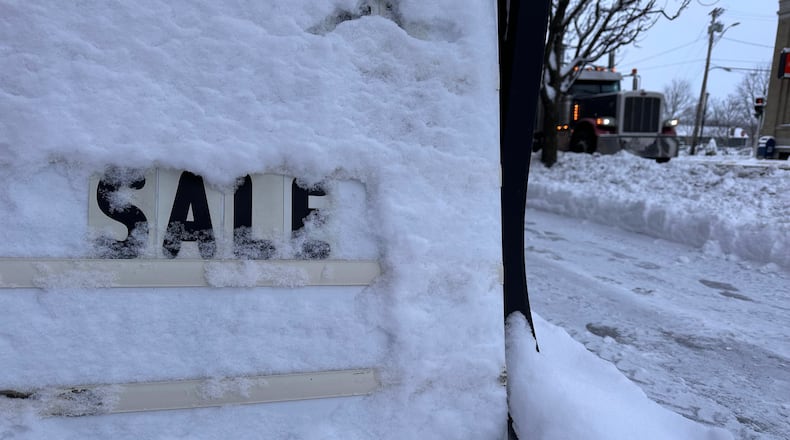 A store's promotional sign is snowed under in Lowville, N.Y., on Friday, Nov. 28, 2025. (AP Photo/Cara Anna)