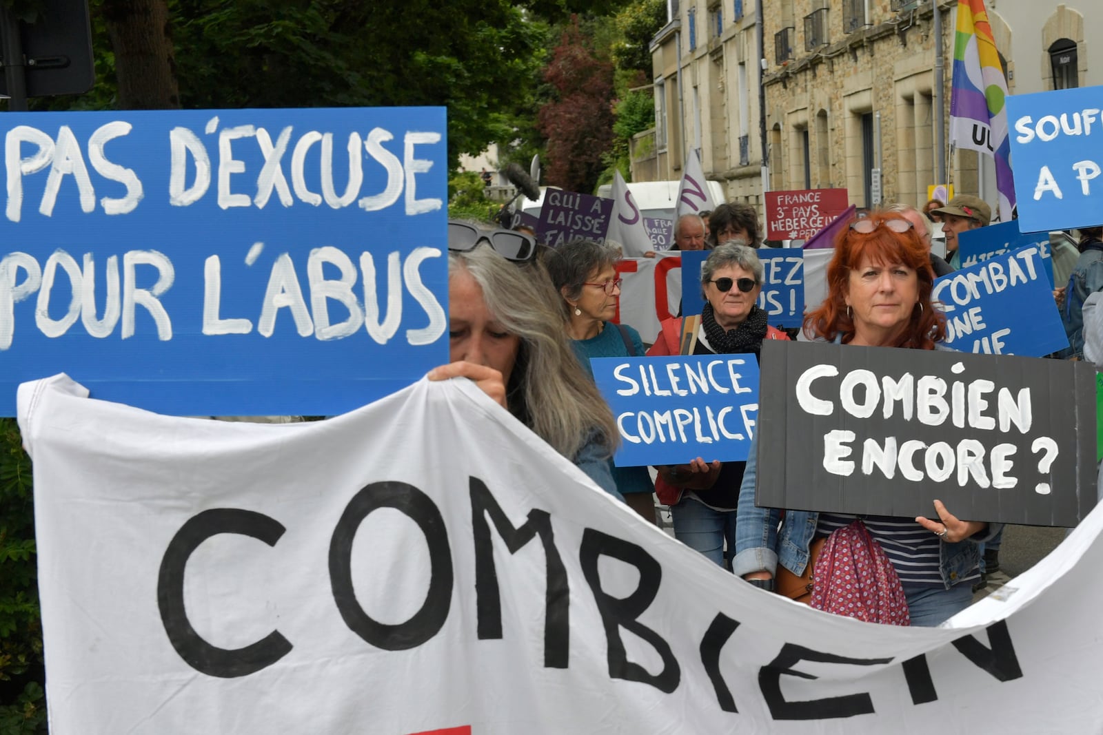 People demonstrate with posters reading "No excuse for abuses", left, and "How many more?", right, ahead of the verdict in the trial of Joel Le Scouarnec, a 74-year-old former surgeon, accused of raping and sexually assaulting 299 children, Wednesday, May 28, 2025 in Vannes, Brittany, western France. (AP Photo/Mathieu Pattier)