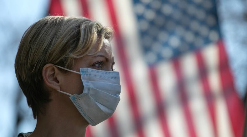 Coronavirus crisis volunteer Rhiannon Navin greets local residents arriving to a food distribution center at the WestCop community center on March 18, 2020 in New Rochelle, New York. (Photo by John Moore/Getty Images)