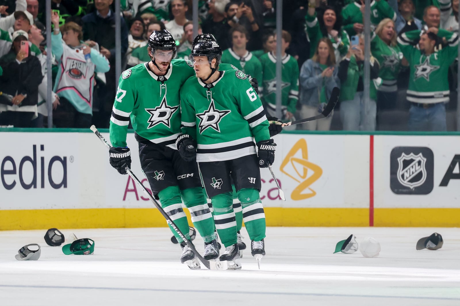Dallas Stars' Mason Marchment (27) and Mikael Granlund, right, celebrate Granlund earning a hat trick in the third period of Game 4 of a second-round NHL hockey playoff series in Dallas, Tuesday, May 13, 2025. (AP Photo/Gareth Patterson)