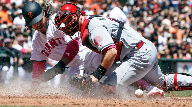 SAN FRANCISCO, CA - MAY 14: Brandon Crawford #35 of the San Francisco Giants scores a run ahead of a tag from Devin Mesoraco #39 of the Cincinnati Reds during the first inning at AT&T Park on May 14, 2017 in San Francisco, California.  Players are wearing pink to celebrate Mother's Day weekend and support breast cancer awareness. (Photo by Jason O. Watson/Getty Images)