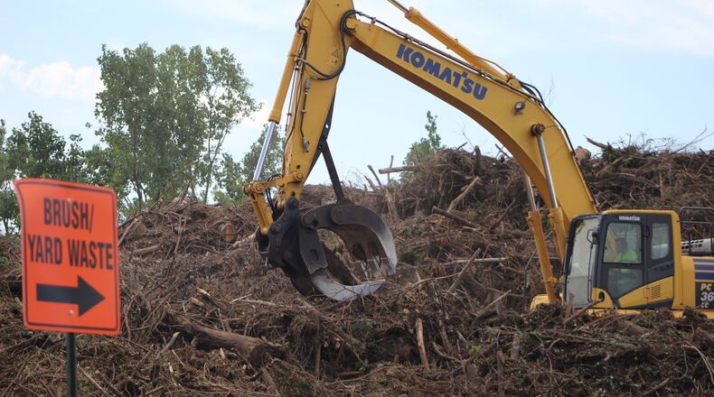 An excavator at work at the green debris collection site on the 2600 block of Wagoner Ford Road in Dayton. CORNELIUS FROLIK / STAFF