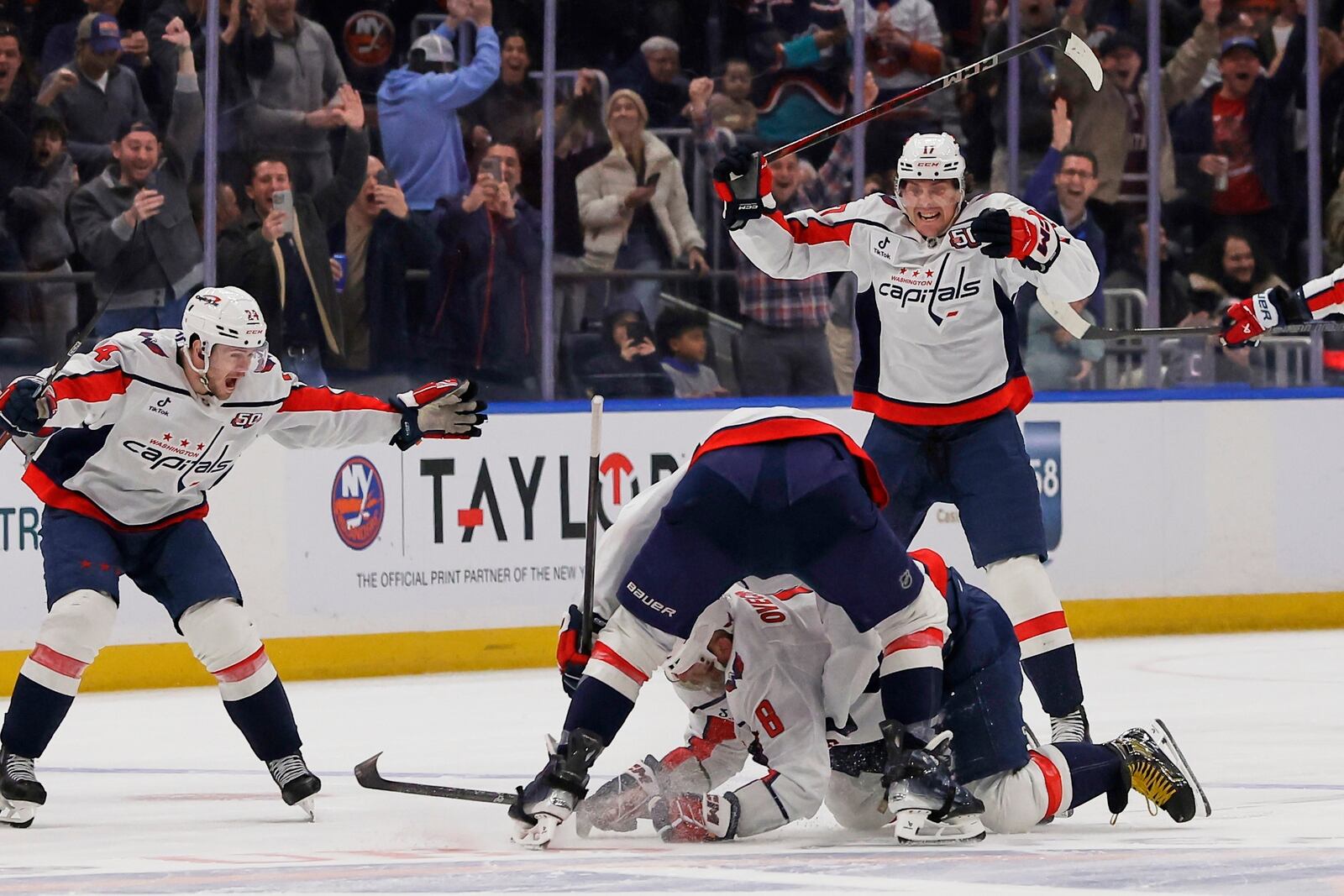 Washington Capitals left wing Alex Ovechkin (8), lower center, is celebrates with his teammates after scoring against New York Islanders during the second period of an NHL hockey game in Elmont, N.Y., Sunday, April 6, 2025. (AP Photo/Adam Hunger)