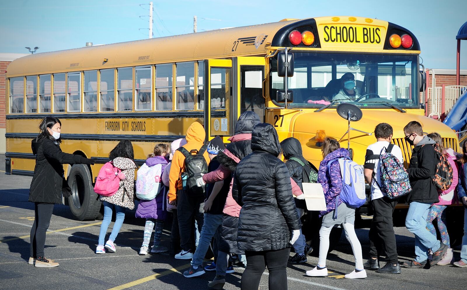 Fairborn city school students board the buses to go home Tuesday, January 11, 2021. MARSHALL GORBY \STAFF