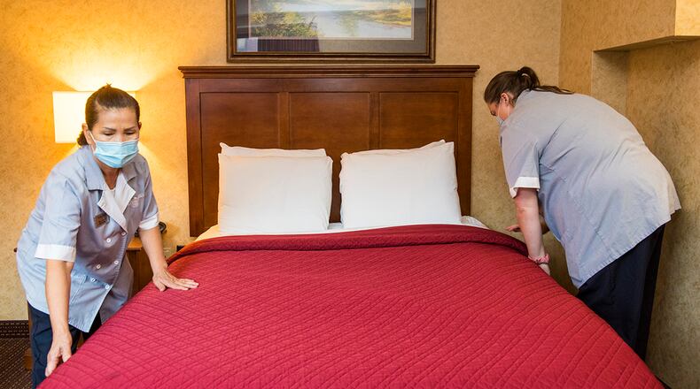 Tuy Leonard (left) and Ashley McDaniel, both housekeepers at Wright-Patterson Inns, prepare a bed in a guestroom. U.S. AIR FORCE PHOTO/JAIMA FOGG