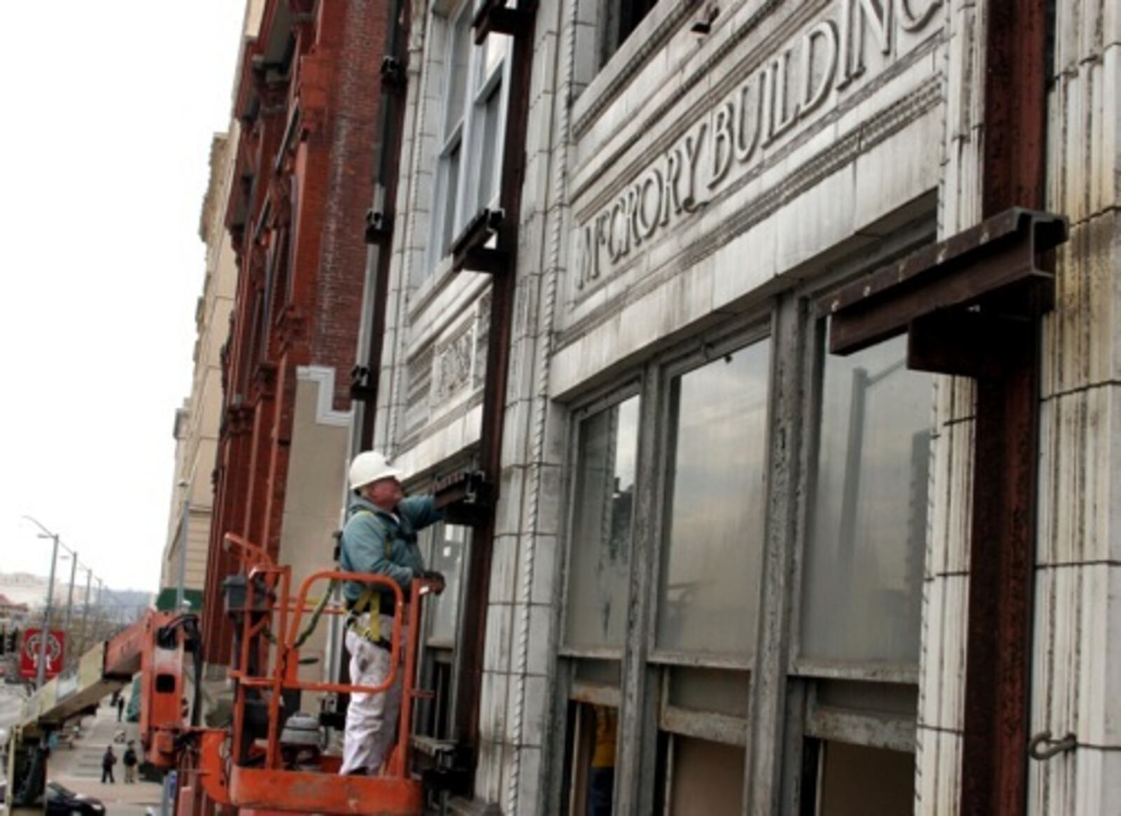 Bud Koogler scrapes and paints windows of the McCrory Building on South Main Street. The aluminum facade that had covered the original building and its window for years was removed as part of renovation by the same company that redid the Kuhn's Building next door.
