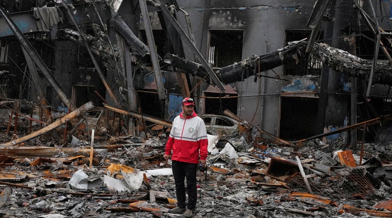 A member of the Iranian Red Crescent Society stands at Hypercar, an auto service center, amid damages which according to the company's officials were caused by strikes on March 1, in Tehran, Iran, Saturday, March 28, 2026. (AP Photo/Vahid Salemi)