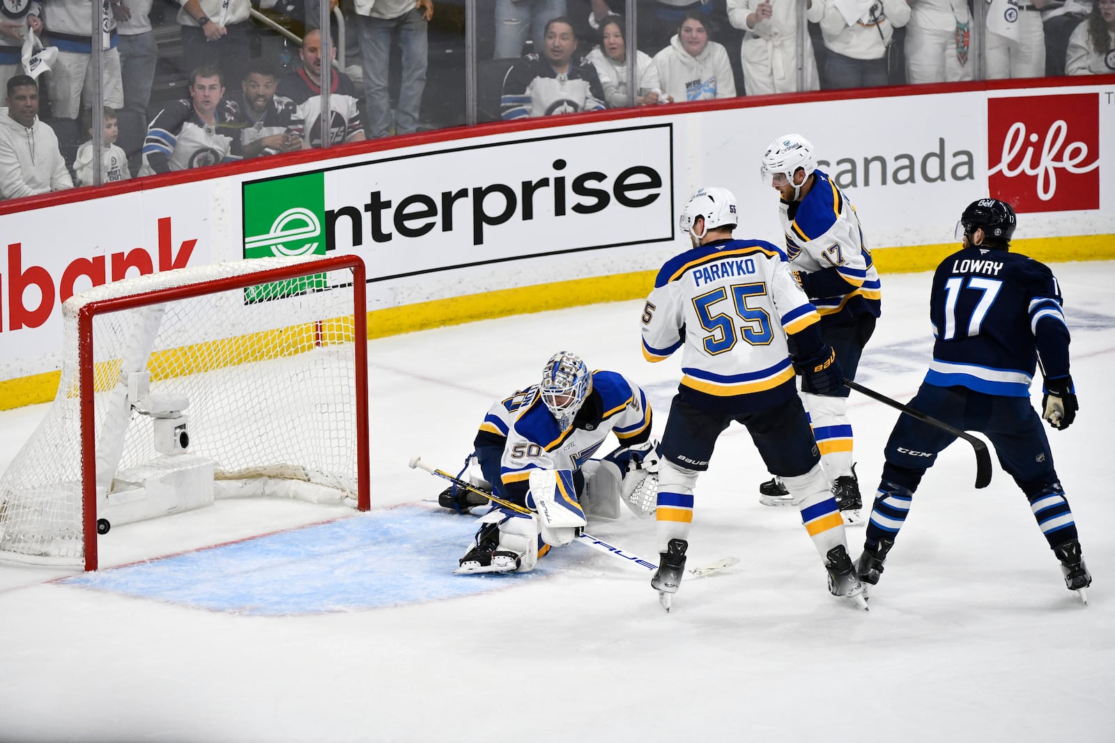 Winnipeg Jets' Adam Lowry (17) scores the game-winning goal against the St. Louis Blues' goaltender Jordan Binnington (50) in the second overtime period of Game 7 in an NHL hockey first-round playoff series in Winnipeg, Manitoba, Sunday, May 4, 2025. (Fred Greenslade/The Canadian Press via AP)