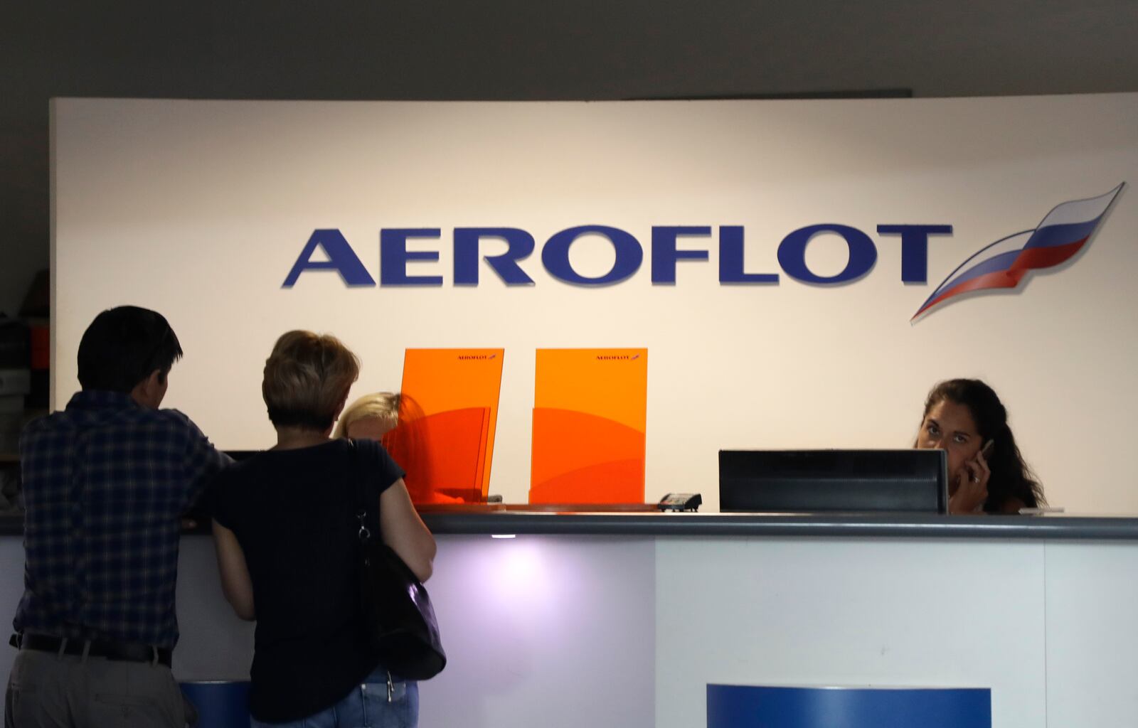 FILE - Customers stand by a counter of Russian airline Aeroflot at the airport in Prague, Czech Republic, Tuesday, July 2, 2019. (AP Photo/Petr David Josek, file)