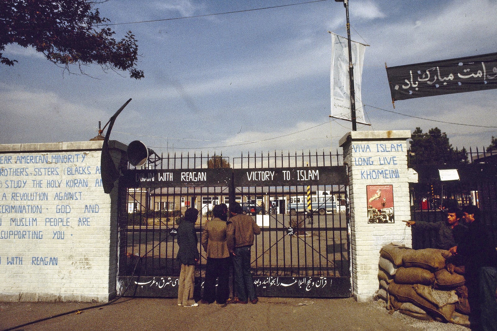 FILE - The entrance to the U.S. Embassy in Tehran, Iran, where 63 people are being held hostage, seen in 1980. Graffiti on the wall at left reads: "Dear American minority, brothers and sisters (Blacks and Indians) study the holy Koran and start a revolution against U.S. discrimination. God and Iranian Muslim people are supporting you. Down with Reagan." (AP Photo, File)