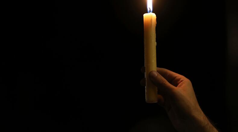 A man holds a candle during a vigil. (AP Photo/Fernando Vergara)