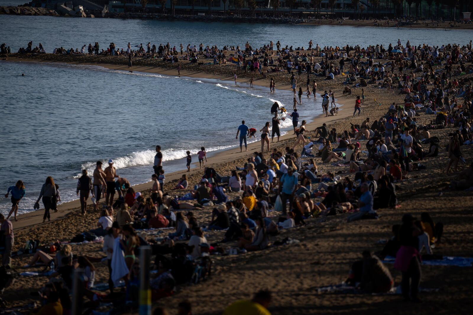 FILE - People sunbathe on a beach in Barcelona, Spain, March 12, 2023. (AP Photo/Emilio Morenatti, File)