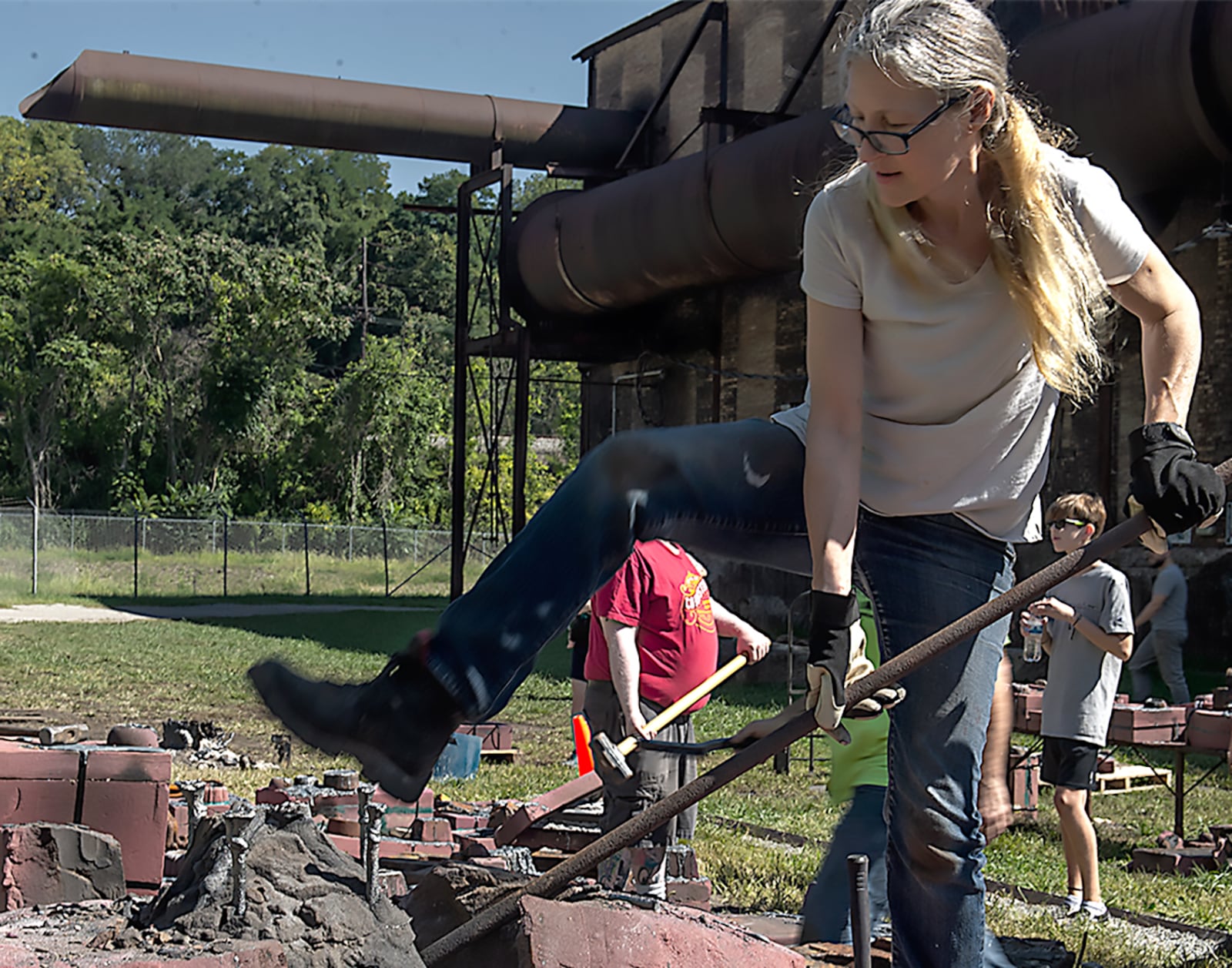 Susan Byrnes prying open a sand mold after an iron casting at Carrie Blast Furnace in Pittsburgh. CLAYTON WEIS/CONTRIBUTED PHOTO