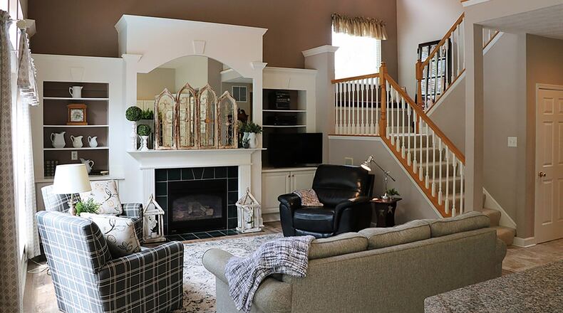 A vaulted ceiling rises above the great room and extends above the open staircase to the upper level. Extensive millwork surrounds the built-in bookshelves, cabinets and TV space, while incorporating the fireplace as its centerpiece.