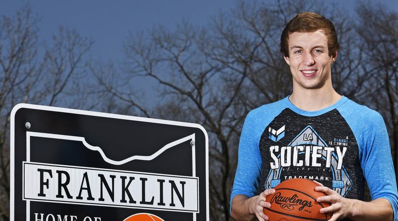 Franklin High School senior Luke Kennard next to one of the signs that have been installed on roads entering the city of Franklin.