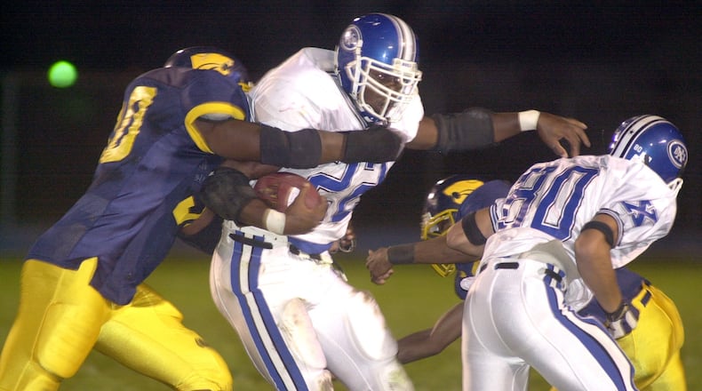 Xenia’s Trent Cole (22) runs through South’s Mitchell Crossley (90), left, and another defender during the first half of a game September 29, 2000. Bill Lackey/STAFF