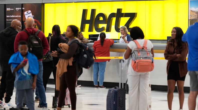 Travelers wait in line at the rental car center at George Bush Intercontinental Airport on Friday, Nov. 7, 2025, in Houston. (AP Photo/Ashley Landis)