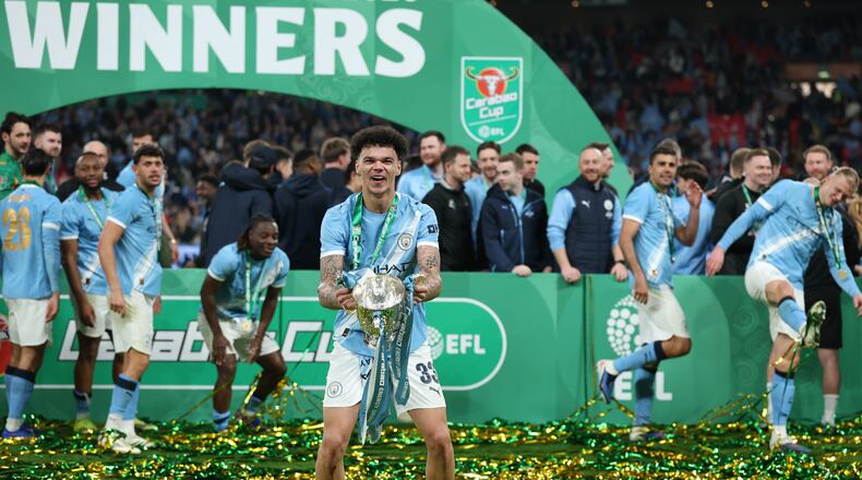 Manchester City's Nico O'Reilly celebrates with the trophy after winning the English League Cup final soccer match between Arsenal and Manchester City in London, Sunday, March 22, 2026. (AP Photo/Richard Pelham)