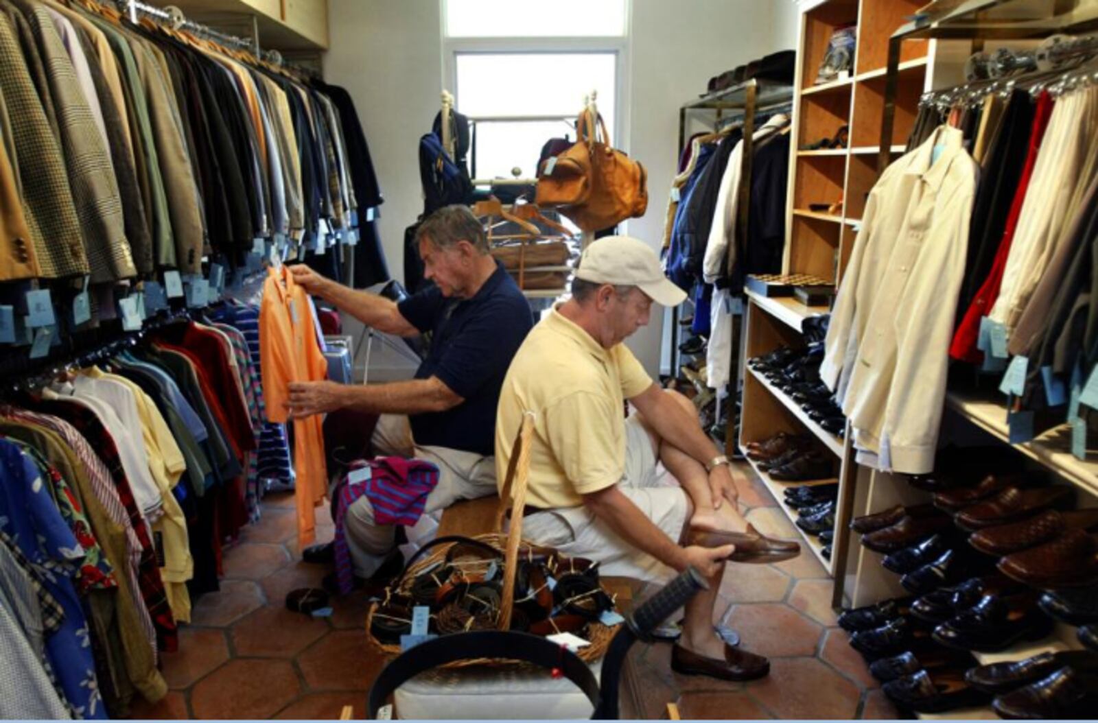 Clayton Willis, left, of Hypoluxo considers a shirt while Bruce Ramsey, right, of West Palm Beach tries some loafers on for size at The Church Mouse in Palm Beach.