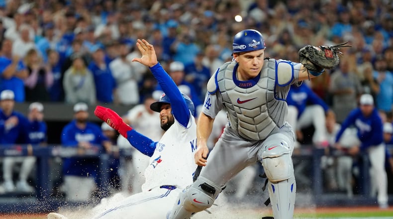 FILE - Toronto Blue Jays' Isiah Kiner-Falefa, left, is forced out at home plate by Los Angeles Dodgers catcher Will Smith during the ninth inning in Game 7 of baseball's World Series in Toronto on Nov. 1, 2025. (Frank Gunn/The Canadian Press via AP, File)