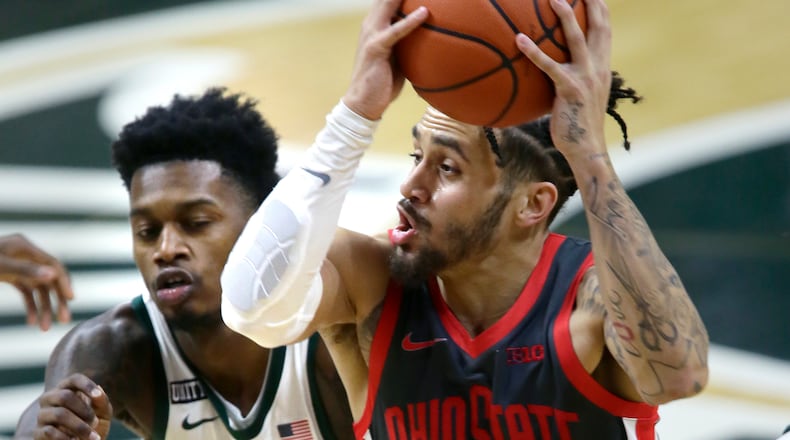 Ohio State guard Duane Washington Jr. drives to the basket against Michigan State guard Rocket Watts during the first half of an NCAA college basketball game Thursday, Feb. 25, 2021, in East Lansing, Mich. (AP Photo/Duane Burleson)