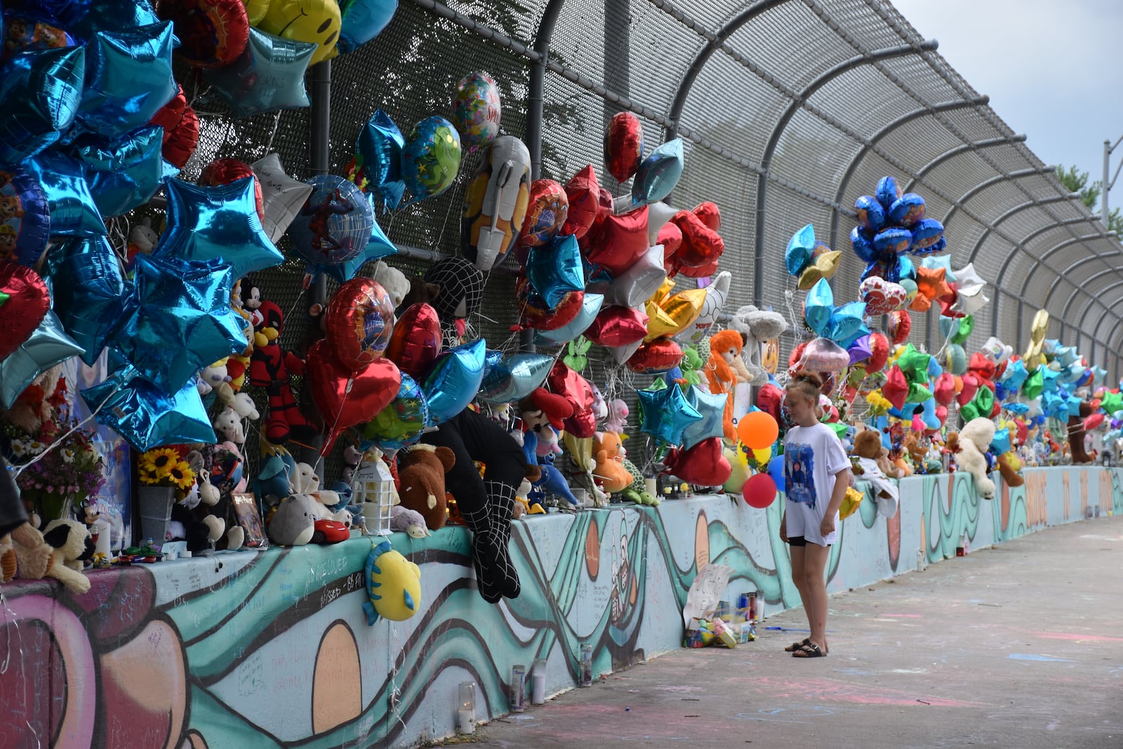 Lavaeh Benner, Hershall Creachbaum Jr.'s cousin, on Tuesday, July 15, 2025 visited a bridge on McClure Street over U.S. 35 where a memorial has been created for the 7-year-old boy. CORNELIUS FROLIK / STAFF