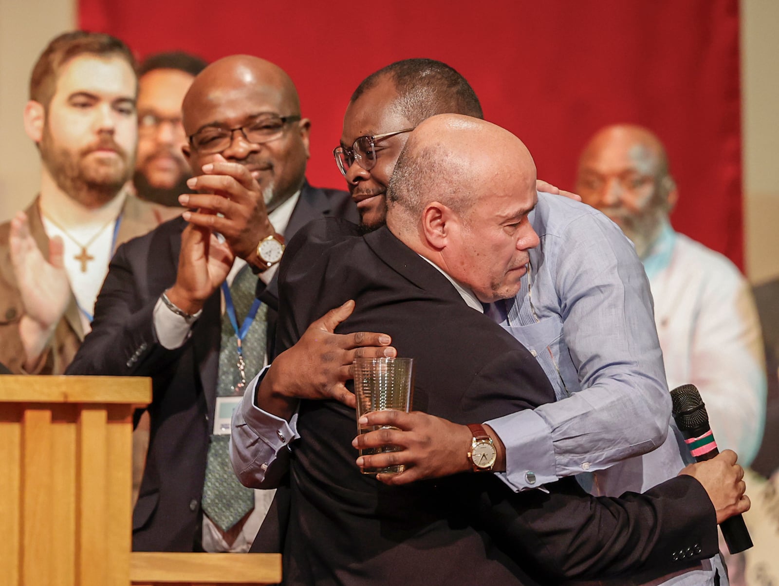 Pastor Jose Salas, front, hugs Viles Dorsainvil, co-founder and executive director of the Haitian Community Help & Support Center, during Here We Stand: Faith Leaders for Immigration Justice & Family Unity at St. John Missionary Baptist Church on Monday, Feb. 2, 2026, in Springfield. Pastors, faith leaders and community members gathered to pray and call for the extension of Temporary Protected Status which is scheduled to expire on Tuesday, Feb. 3, 2026. JOSEPH COOKE/STAFF