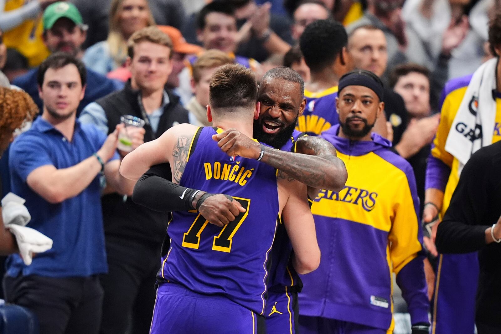 Los Angeles Lakers' Luka Doncic (77) and LeBron James, center, right, hug and celebrate late in the second half of an NBA basketball game against the Dallas Mavericks in Dallas, Wednesday, April 9, 2025. (AP Photo/LM Otero)