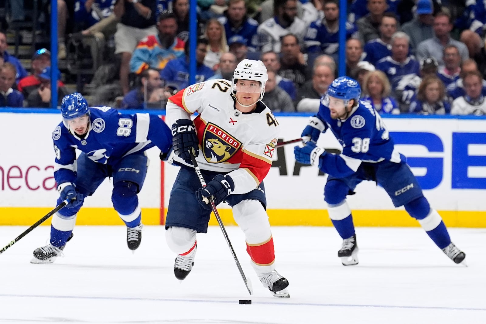 Florida Panthers defenseman Gustav Forsling (42) breaks out ahead of Tampa Bay Lightning center Gage Goncalves (93) and left wing Brandon Hagel (38) during the third period in Game 2 of an NHL hockey Stanley Cup first-round playoff series, Thursday, April 24, 2025, in Tampa, Fla. (AP Photo/Chris O'Meara)