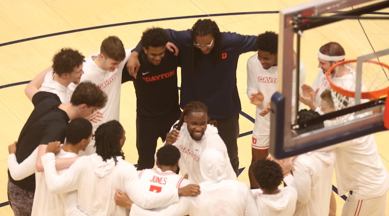 Dayton's Jaiun Simon dances in the middle of a team huddle before a game against George Washington on Tuesday, Jan. 6, 2026, at UD Arena. David Jablonski/Staff