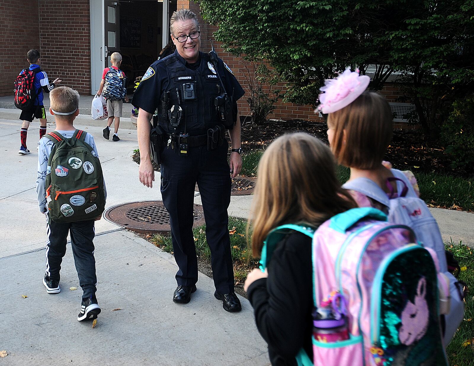 Centerville Police officer Tracy Sommers greets students as they arrive at Cline Elementary in Centerville for the first day of school Wednesday, Aug. 16, 2023 . MARSHALL GORBY\STAFF