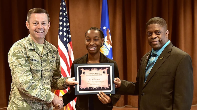 Col. Bradley McDonald (left), 88th Air Base Wing commander, and Terrance Williams (right), president of the local Greater Daytonl Blacks in Government chapter, present the annual Black History Month Scholarship to Alanna Wall, a senior at Stivers High School for the Arts, in a ceremony at Wright-Patterson Air Force Base, Feb. 21. Black History Month is an annual celebration of achievements by African Americans and a time for recognizing the central role of blacks in U.S. history. (U.S. Air Force photo/Al Bright)