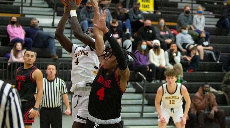 Centerville's Emmanuel Deng puts up a shot against Wayne's Prophet Johnson during a game this season. Jeff Gilbert/CONTRIBUTED
