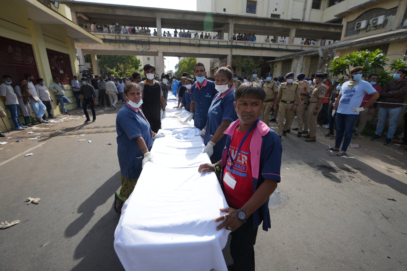 Workers of Civil Hospital wait to receive remains of victims of an airplane that crashed in India's northwestern city of Ahmedabad in Gujarat state, Thursday, June 12, 2025. (AP Photo/Ajit Solanki)