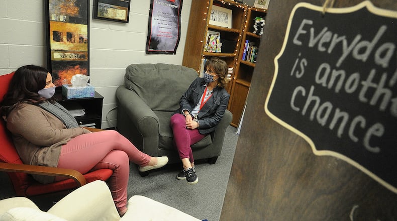 Troy MIddle School Guidance Counselors,  Jennifer Augustine, left, and Kelly Leganik, consult with each other Monday, March 15, 2021. Augistine has many positive signs hanging on her office door. MARSHALL GORBY\STAFF