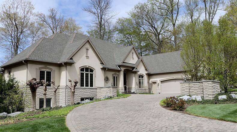 The 4-bedroom home with a finished lower level has about 5,080 sq. ft. of living space. A curved drive leads up to the 3-car garage and extra parking pad. The drive offers a front patio setting surrounded by cypress trees. CONTRIBUTED PHOTO BY KATHY TYLER