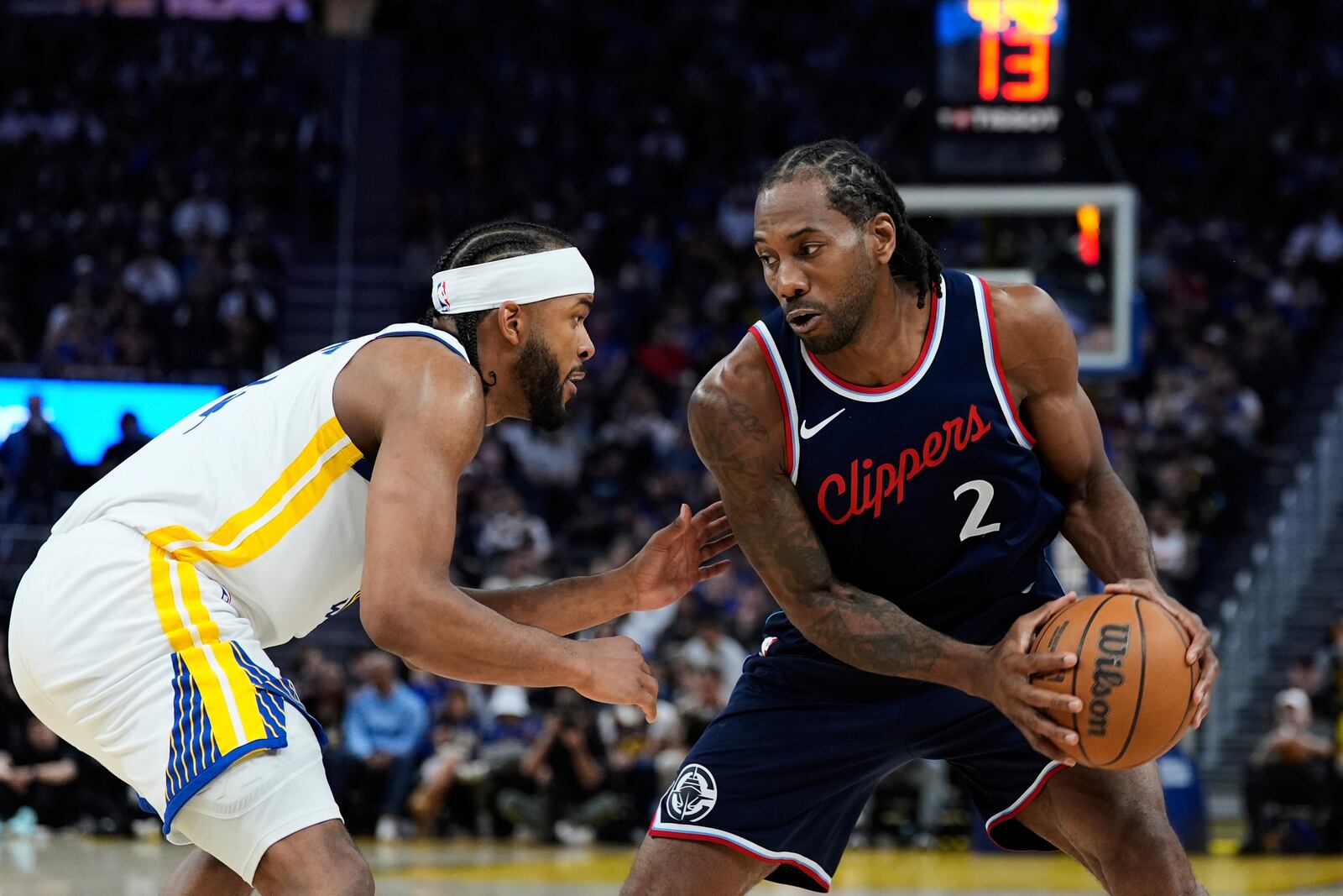 Los Angeles Clippers forward Kawhi Leonard, right, moves the ball while defended by Golden State Warriors guard Moses Moody during the second half of an NBA basketball game Sunday, April 13, 2025, in San Francisco. (AP Photo/Godofredo A. Vásquez)