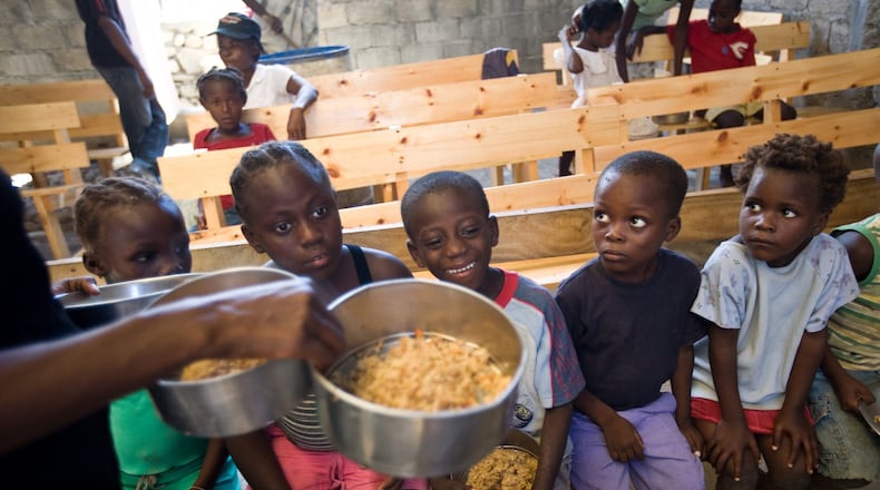 Haitian orphans patiently wait for meals inside a church supplied by A Child’s Hope International. CONTRIBUTED
