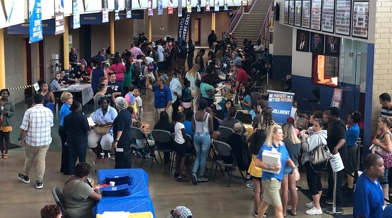 People sitting and standing in line Sunday at Ponitz, waiting to register their kids for this school year.