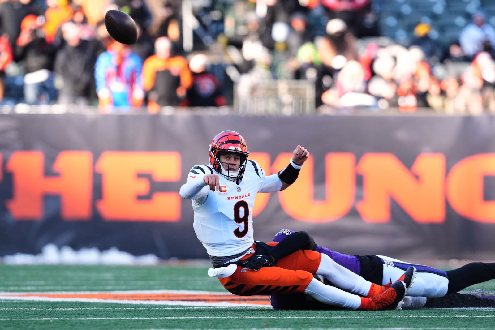 Cincinnati Bengals quarterback Joe Burrow (9) throws as he is tackled by Baltimore Ravens linebacker Kyle van Noy during the second half of an NFL football game, Sunday, Dec. 14, 2025, in Cincinnati. (AP Photo/Jeff Dean)