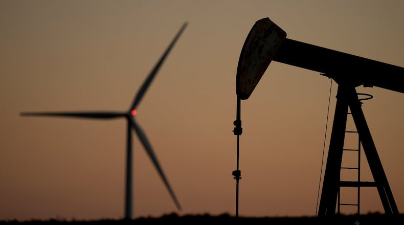FILE - A pumpjack operates in the foreground while a wind turbine at the Buckeye Wind Energy wind farm rises in the distance, Sept. 30, 2024, near Hays, Kan. (AP Photo/Charlie Riedel, File)