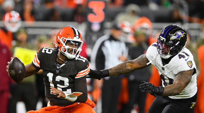 Cleveland Browns quarterback Shedeur Sanders (12) is pressured out of the pocket by Baltimore Ravens' Dre'Mont Jones (41) in the second half of an NFL football game in Cleveland, Sunday, Nov. 16, 2025. (AP Photo/David Richard)